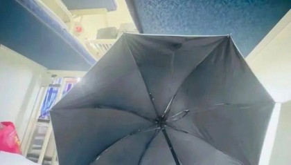 女生躺火车卧铺打伞遮隐私,“过道坐着两名陌生男乘客”,12306回应